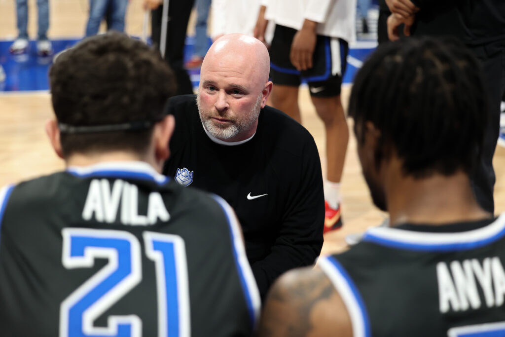 SLU head coach Josh Schertz gives the team some pre-game instruction before tip-off against St. Joe's