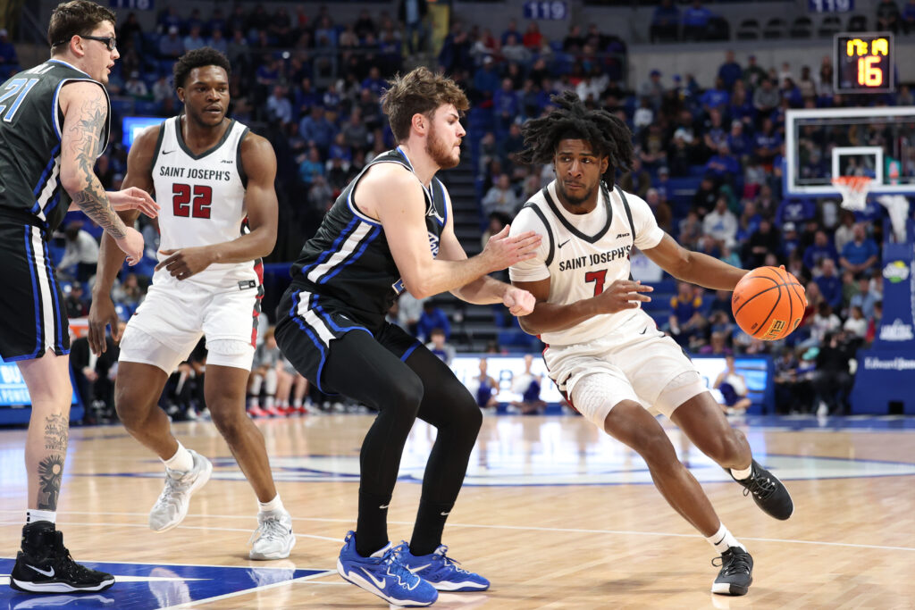 Hawks freshman (r) Dasear Haskins tries to drive on SLU senior Gibson Jimerson