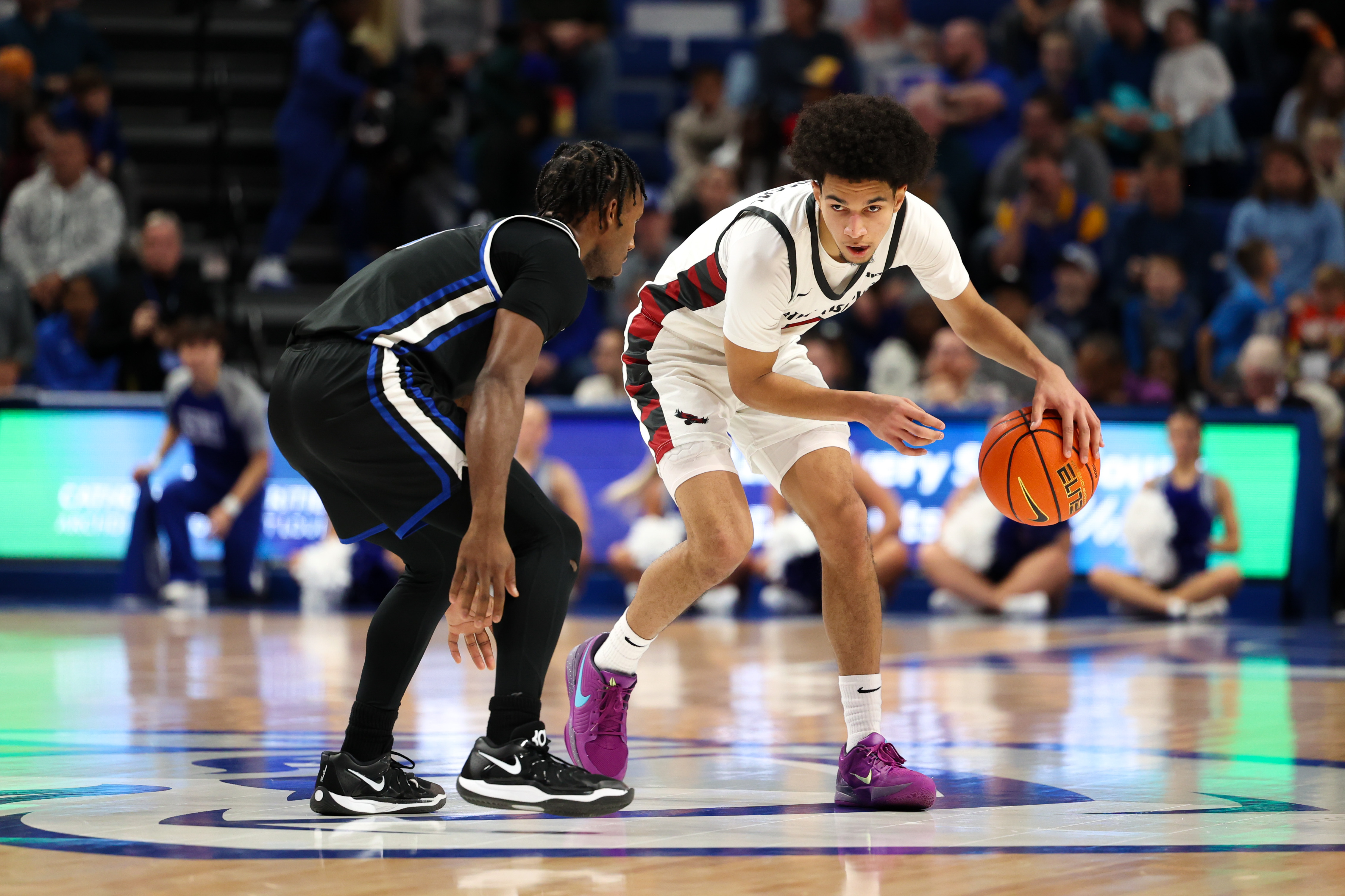 St. Joe junior guard Derek Simpson is guarded by SLU senior guard Isaiah Swope