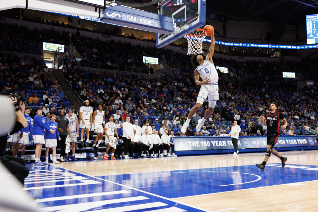 SLU's Kellen Thames throws down a thunderous dunk to the delight of the SLU bench as SJU guard Khaafiq Myers can only watch. (Jeff Brown)