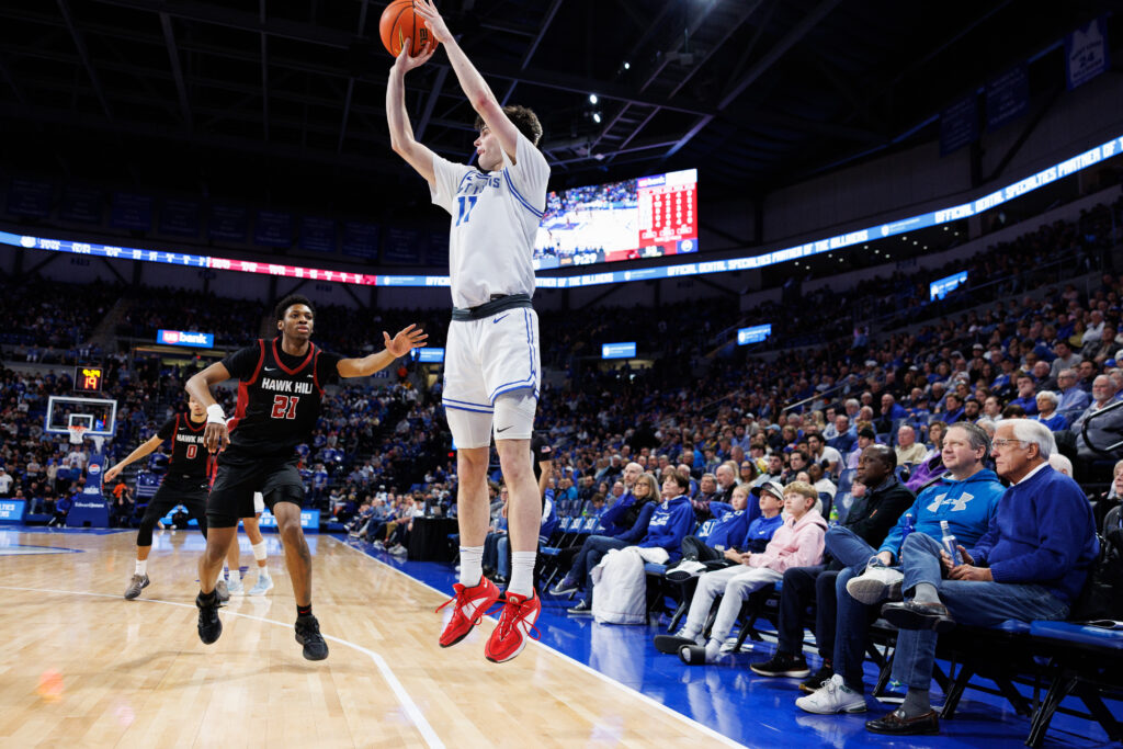 Brady Dunlap let's go a three-pointer for SLU as SJU forward Al Amadou tries to defend. (photo: Jeff Brown)